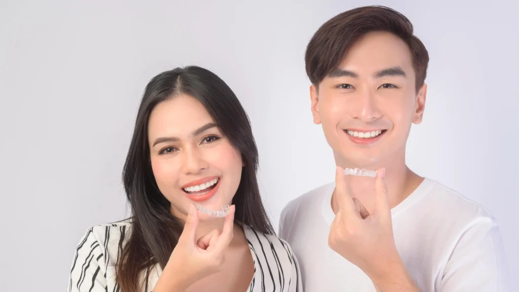Asian couple holding their new invisalign west palm beach