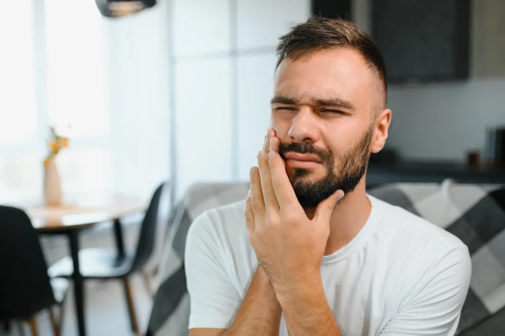 A young man suffering from toothache, in need of emergency orthodontist in West Palm Beach