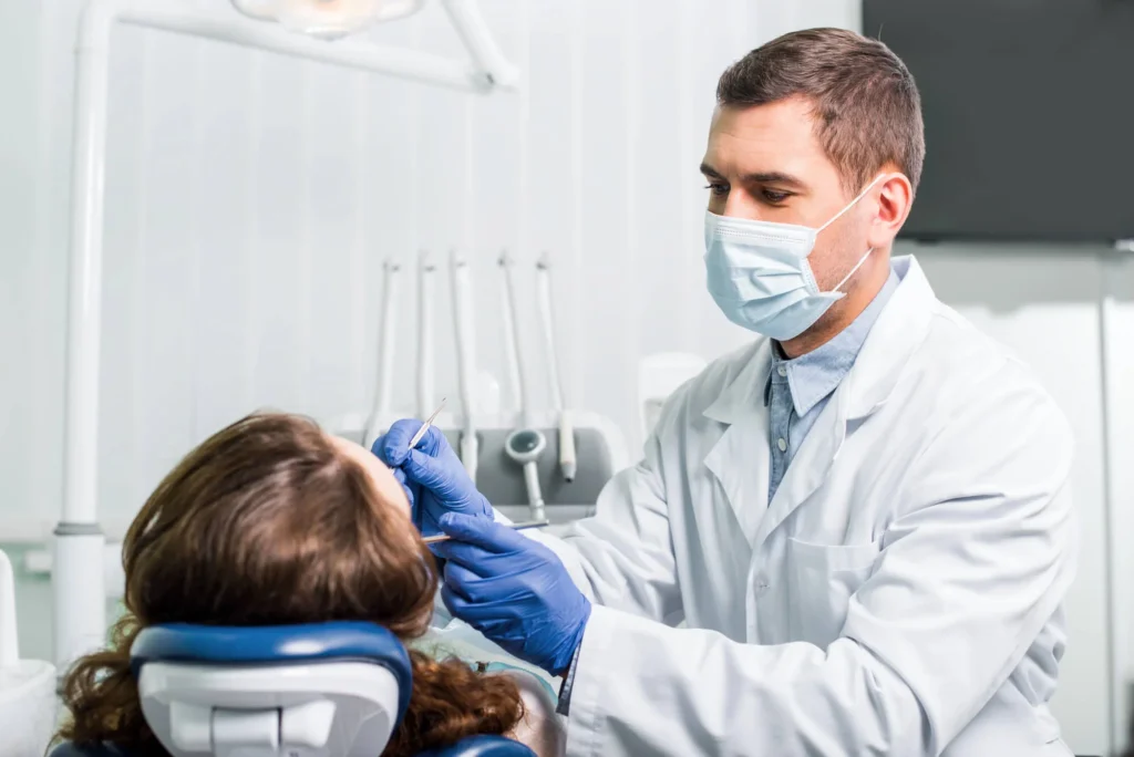 Emergency orthodontist in West Palm Beach, wearing a mask, working with latex-gloved hands