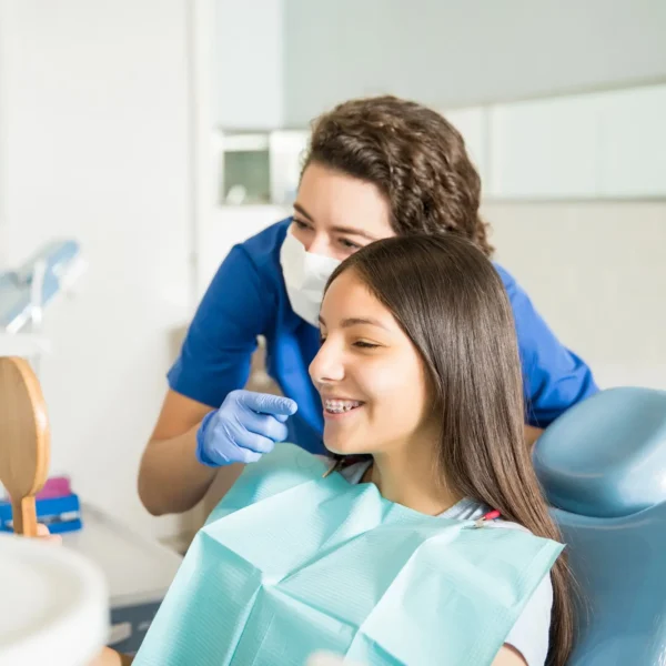 Orthodontist Palm Beach Gardens showing braces to a teen.