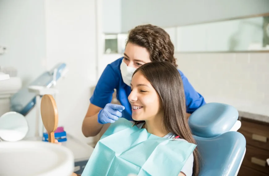 Orthodontist Palm Beach Gardens showing braces to a teen.